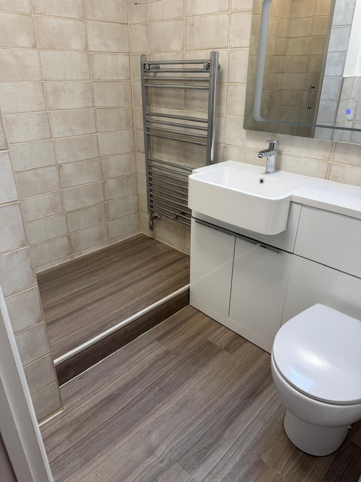 Bathroom refit in progress with vanity unit and towel rail fitted before the shower enclosure