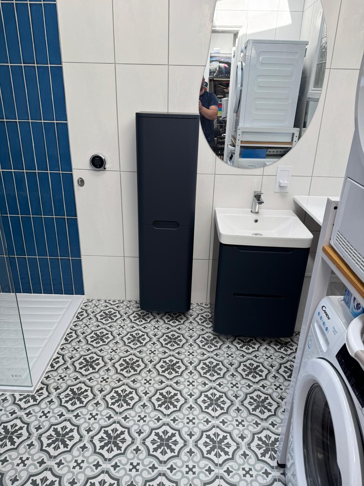 Blue and white tiled shower room with anthracite vanity and tall storage unit