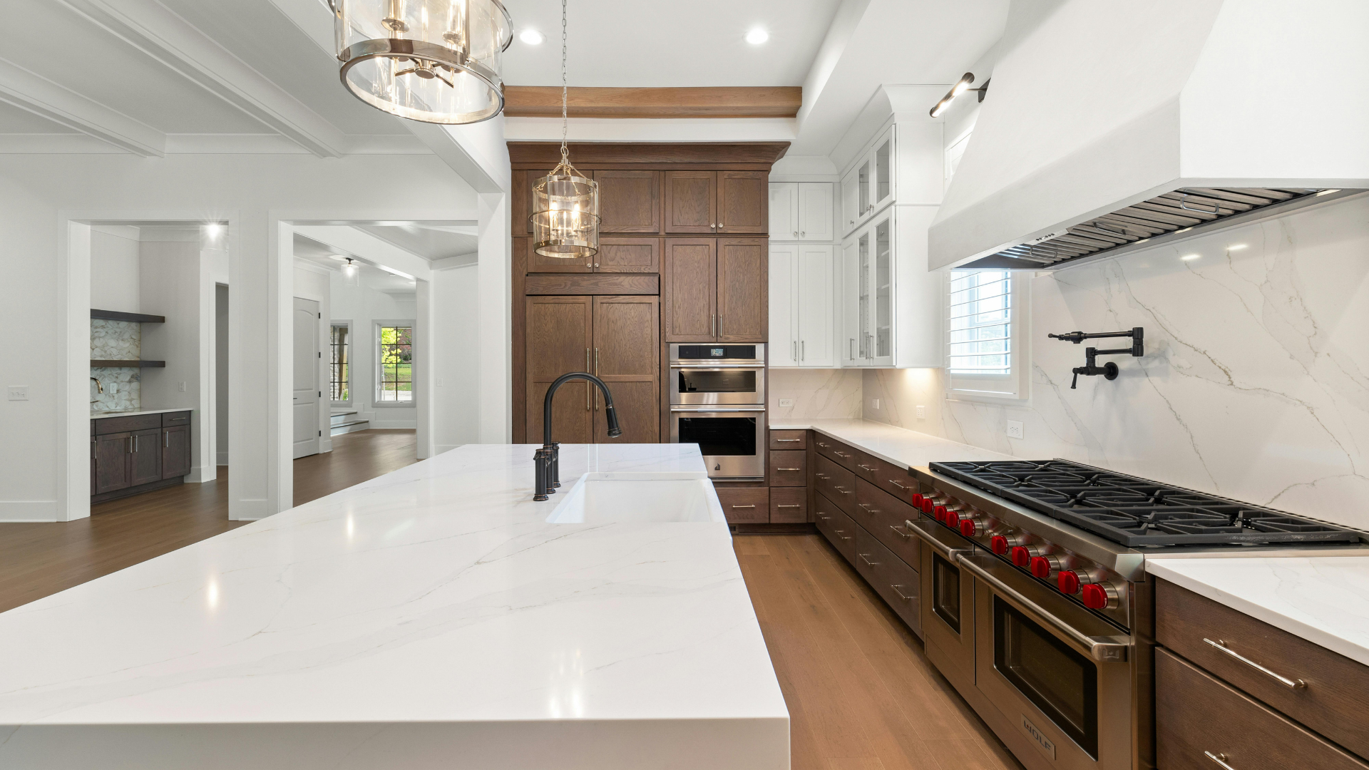 Fitted kitchen with quartz island, oak cabinetry and integrated appliances