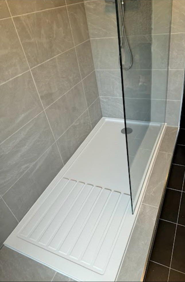 Low-profile shower tray with glass screen and grey wall tiling