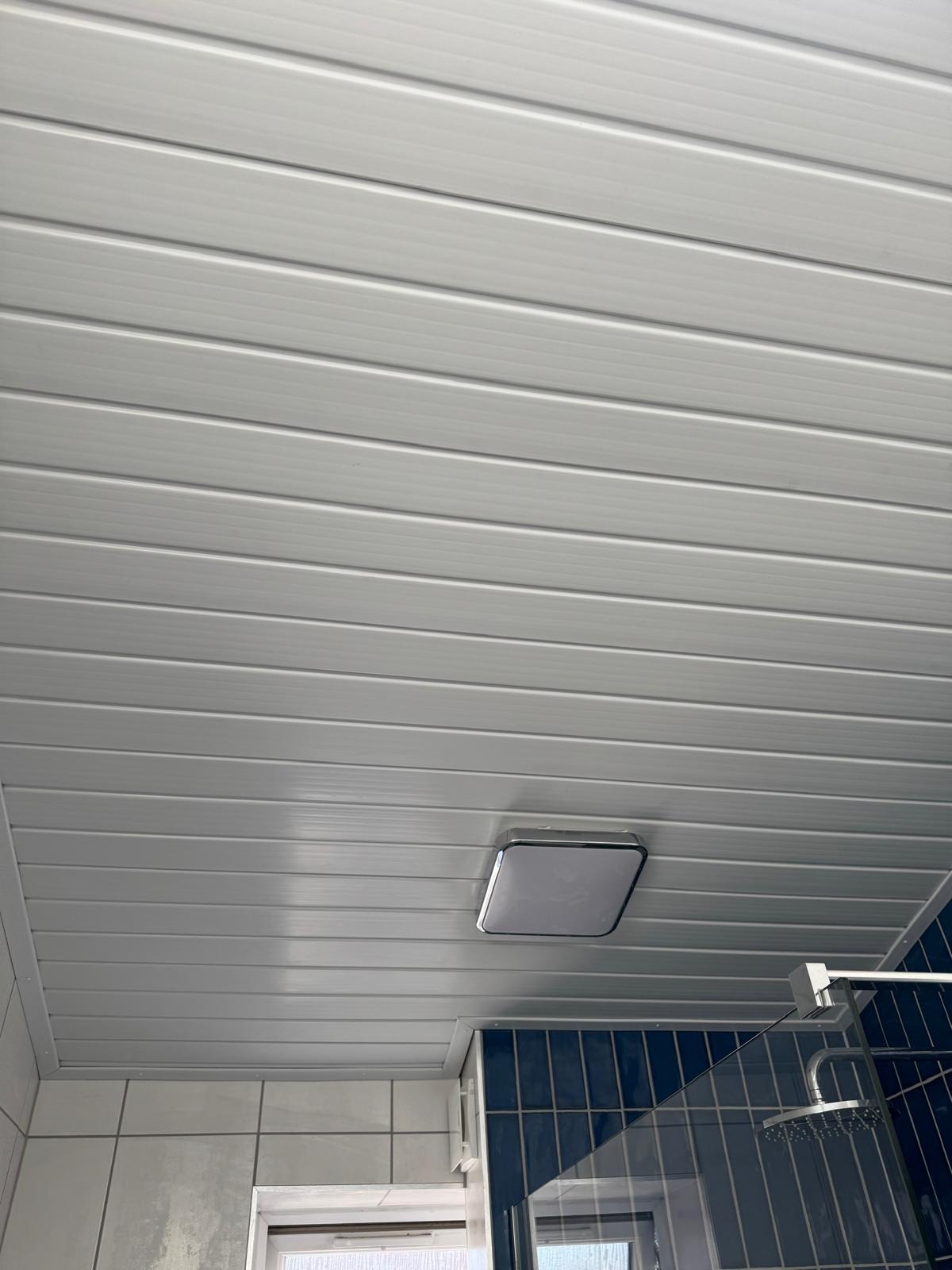 Ceiling LED light and panelled ceiling finished in a completed bathroom refit